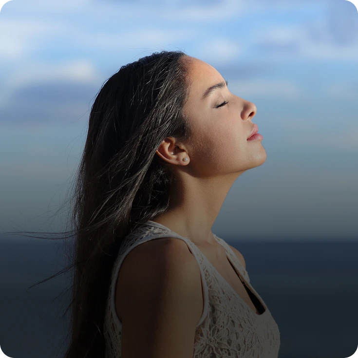 Woman with eyes closed by the sea – online psychiatry in Santa Fe, NM